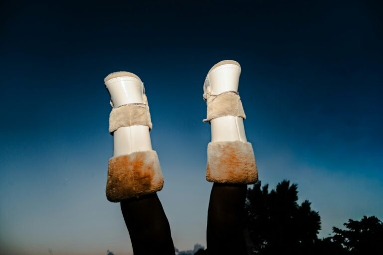 Tall white boots with tan faux fur trim worn outdoors