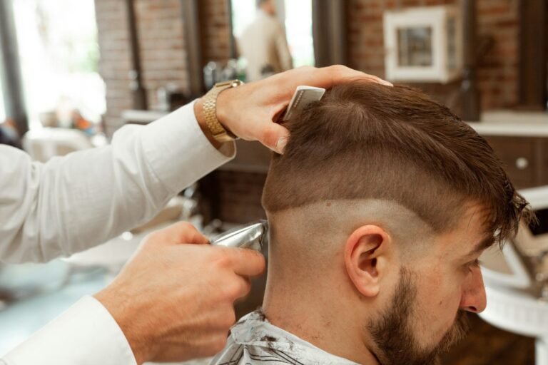 Barber in a white shirt cutting a man's hair