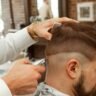 Barber in a white shirt cutting a man's hair