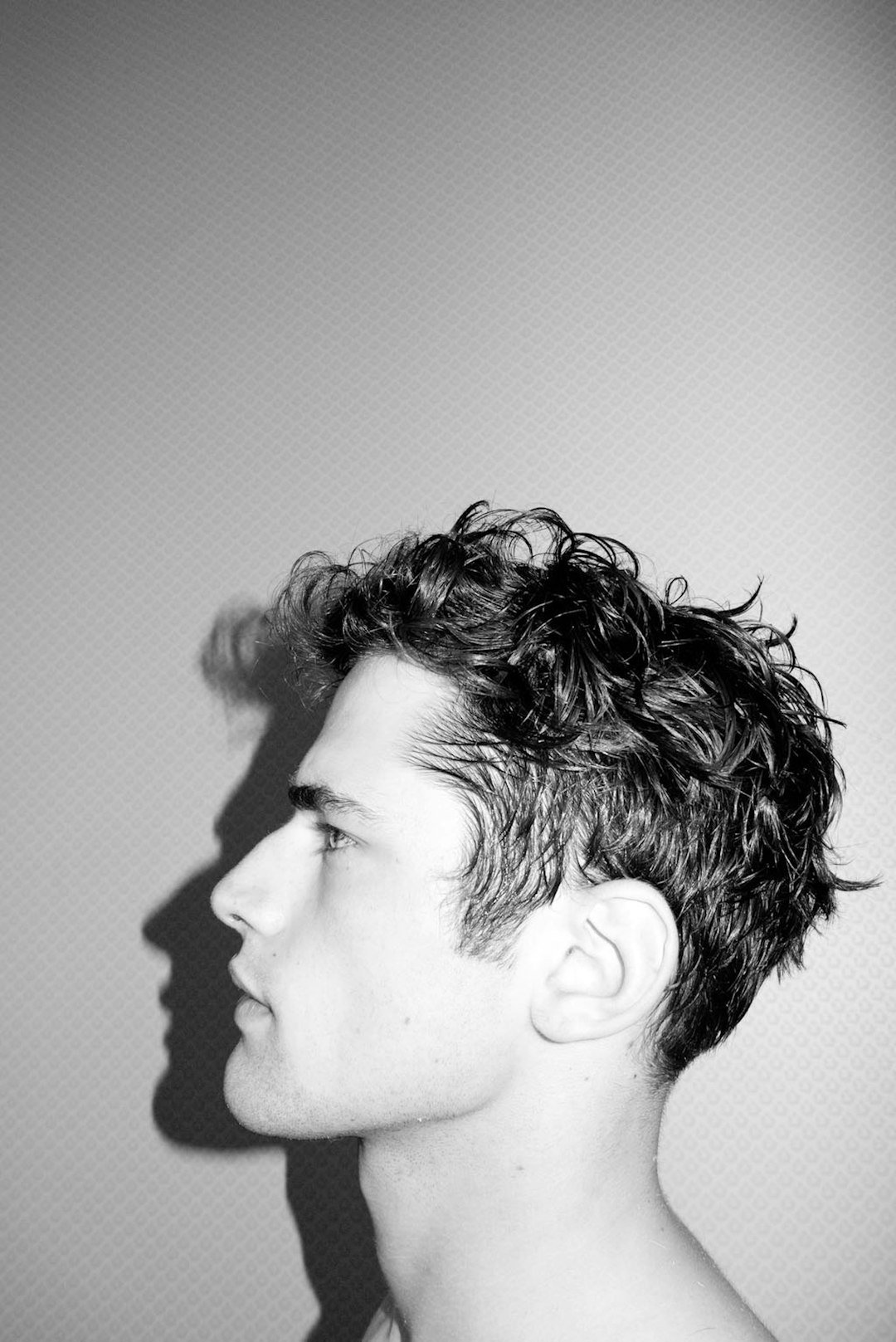 Side profile of a young man with curly hair